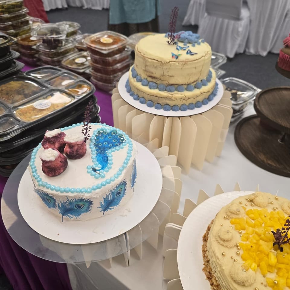 Celebration cakes and cupcakes beside prepared meals