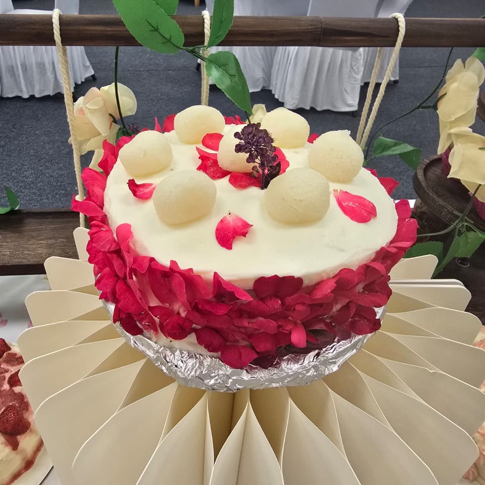 Cake decorated with rose petals and round sweets